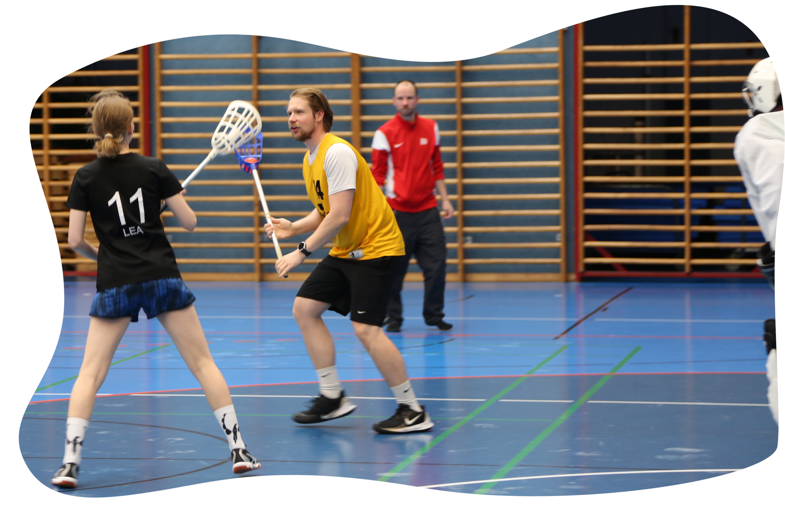 Spieler führt Ball mit Stick und versucht an einer Spielerin vorbeizukommen